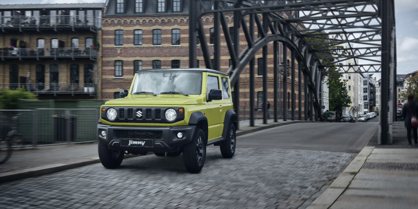 Vehículo Jimny color amarillo kinético, en la ciudad.
