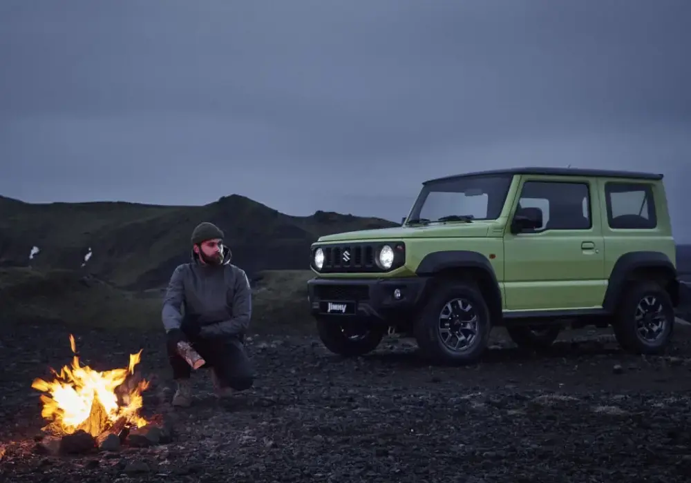 Suzuki Jimny color verde lima estacionado en un terreno rocoso