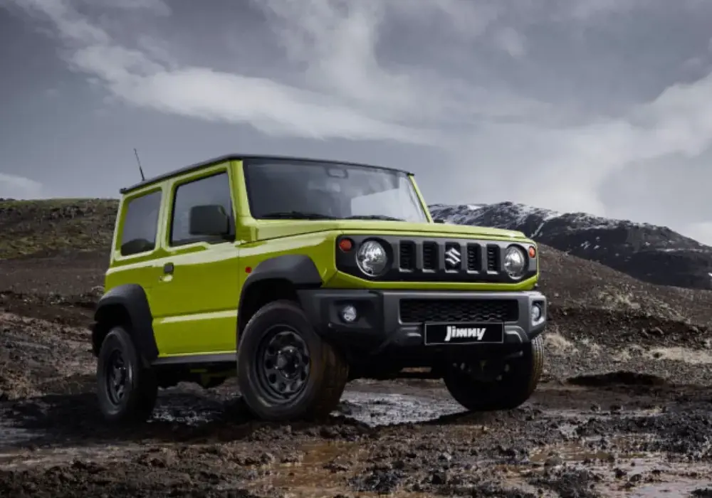 Suzuki Jimny color verde estacionado en terreno rocoso