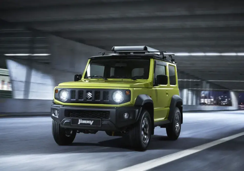 Suzuki Jimny amarillo en una carretera urbana